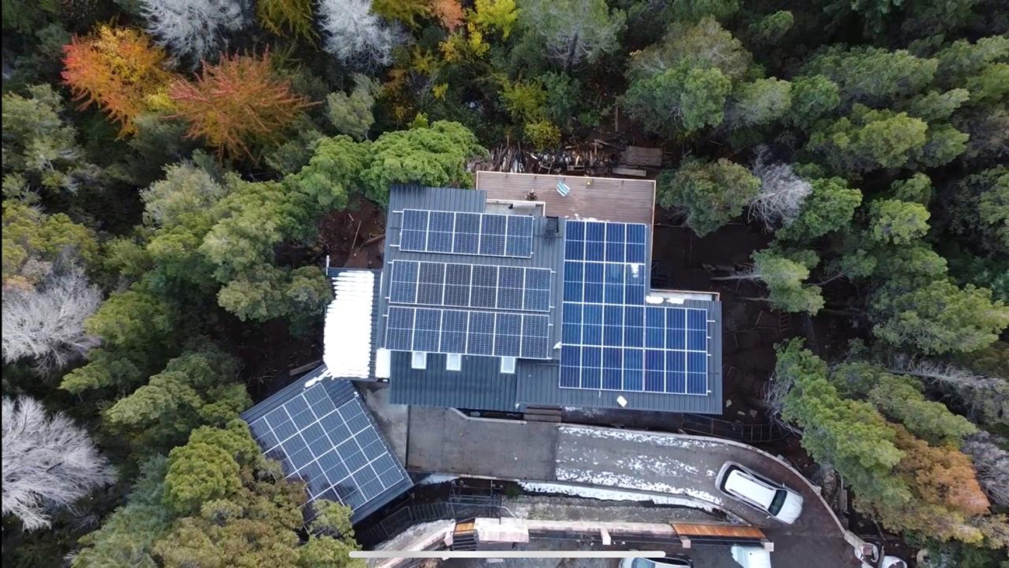 Vista aérea del techo de Altué Lodge con los paneles solares, rodeado de bosque