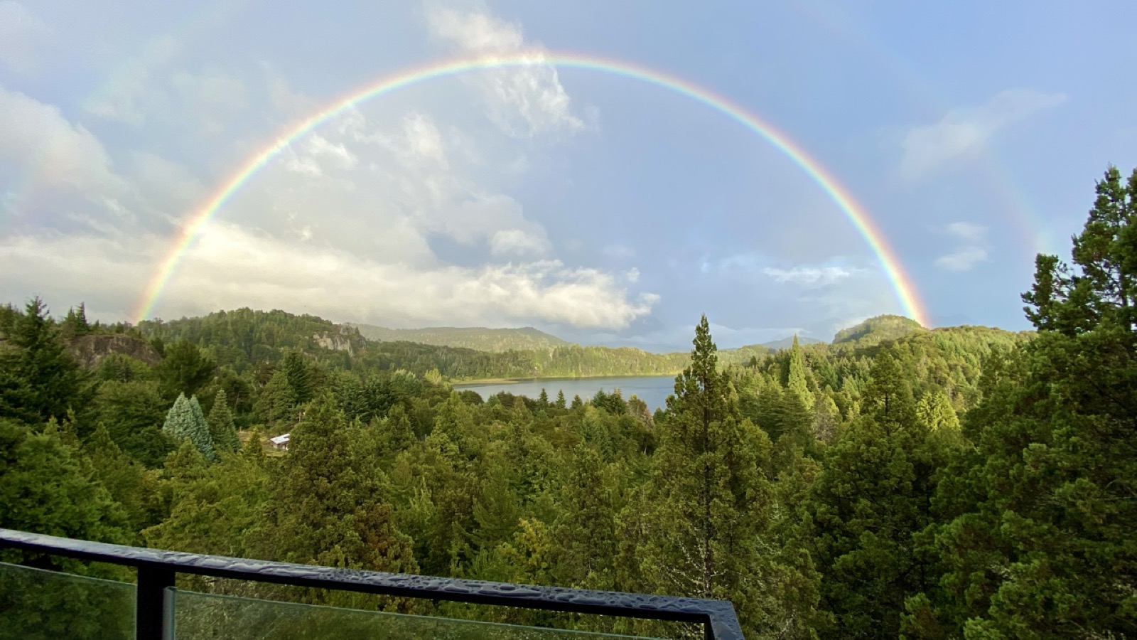Doble arcoíris sobre el bosque y el lago, visto desde el balcón