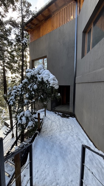 Fachada de Altué Lodge entre los árboles nevados