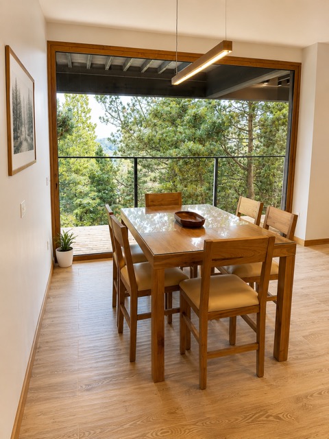 Mesa de comedor con vista al bosque a través del ventanal